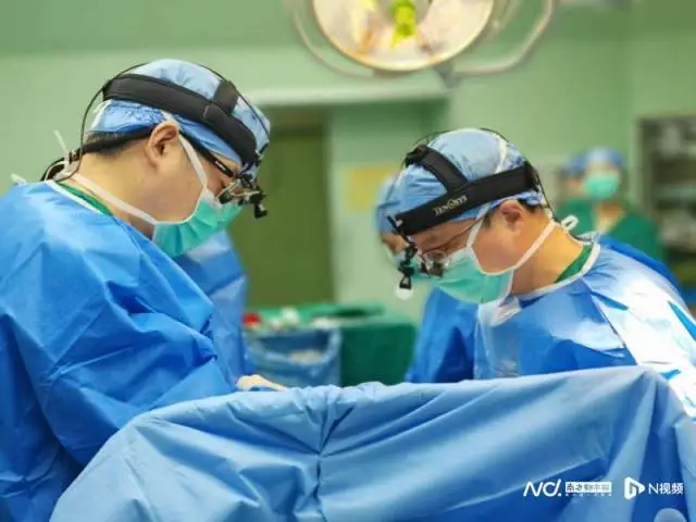 Cardiac surgeons wearing headlamps and loupes performing a heart procedure in the operating theatre